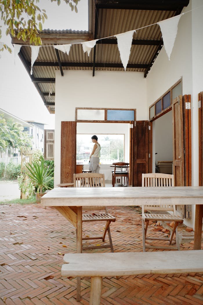 Crafting Captivating Headlines: Your awesome post title goes here A serene outdoor dining area with wooden furniture and brick flooring, showcasing modern architecture in Bangkok.